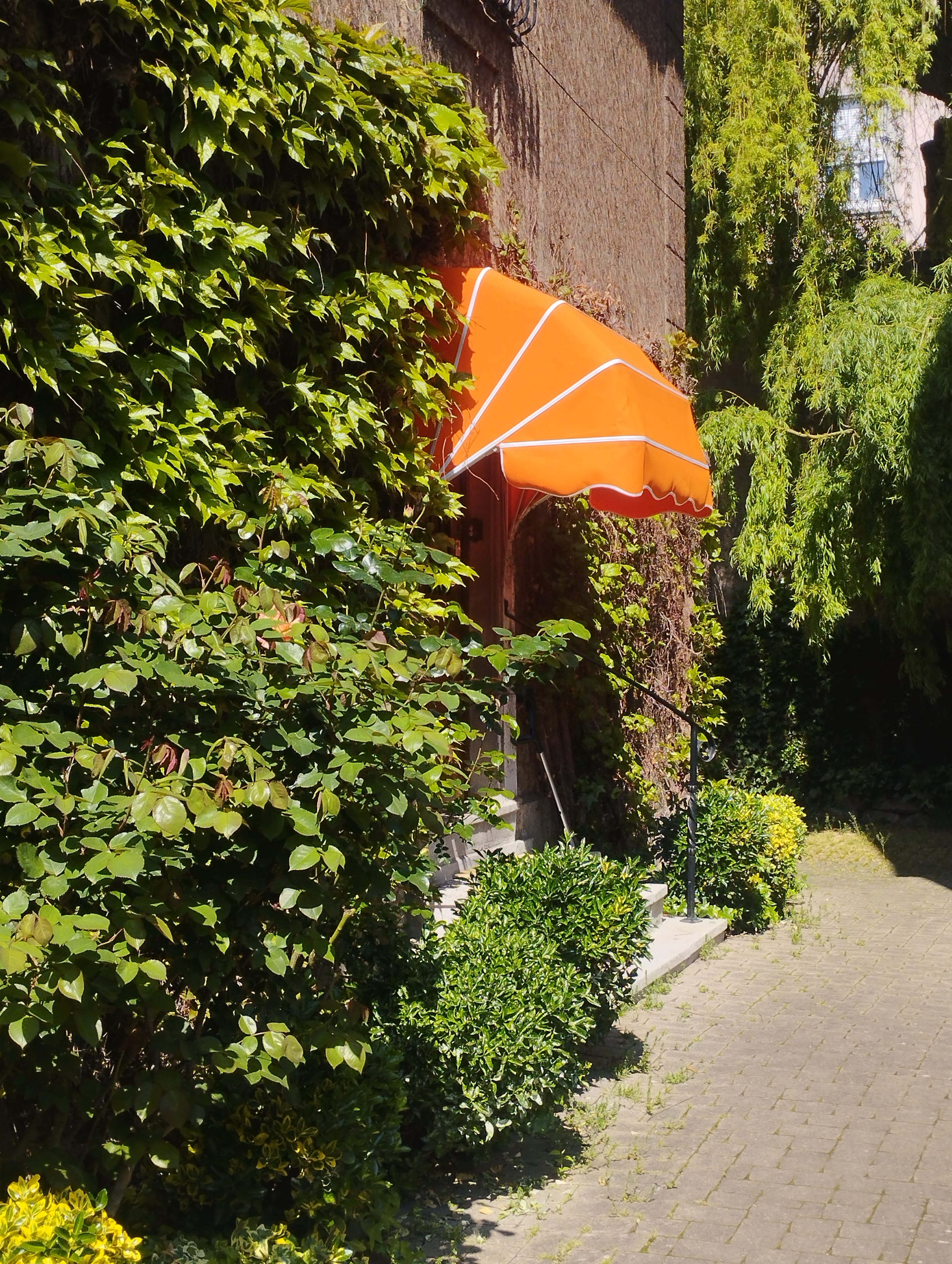 uvent d’entrée orange installé sur façade de maison, protection contre la pluie et le soleil à Colmar