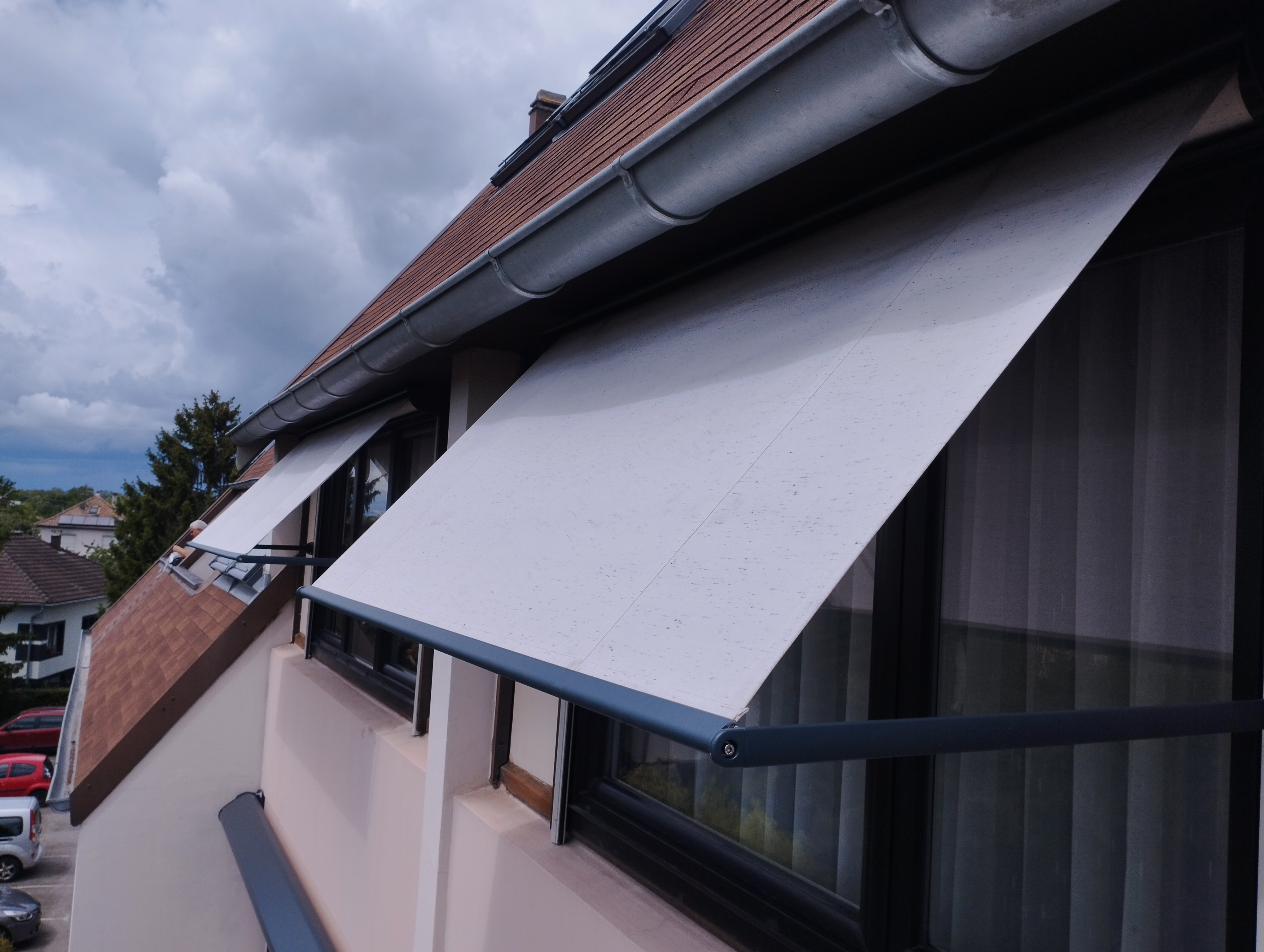 Stores bannes extérieurs inclinés installés sur fenêtres de maison, protection solaire en Haut-Rhin