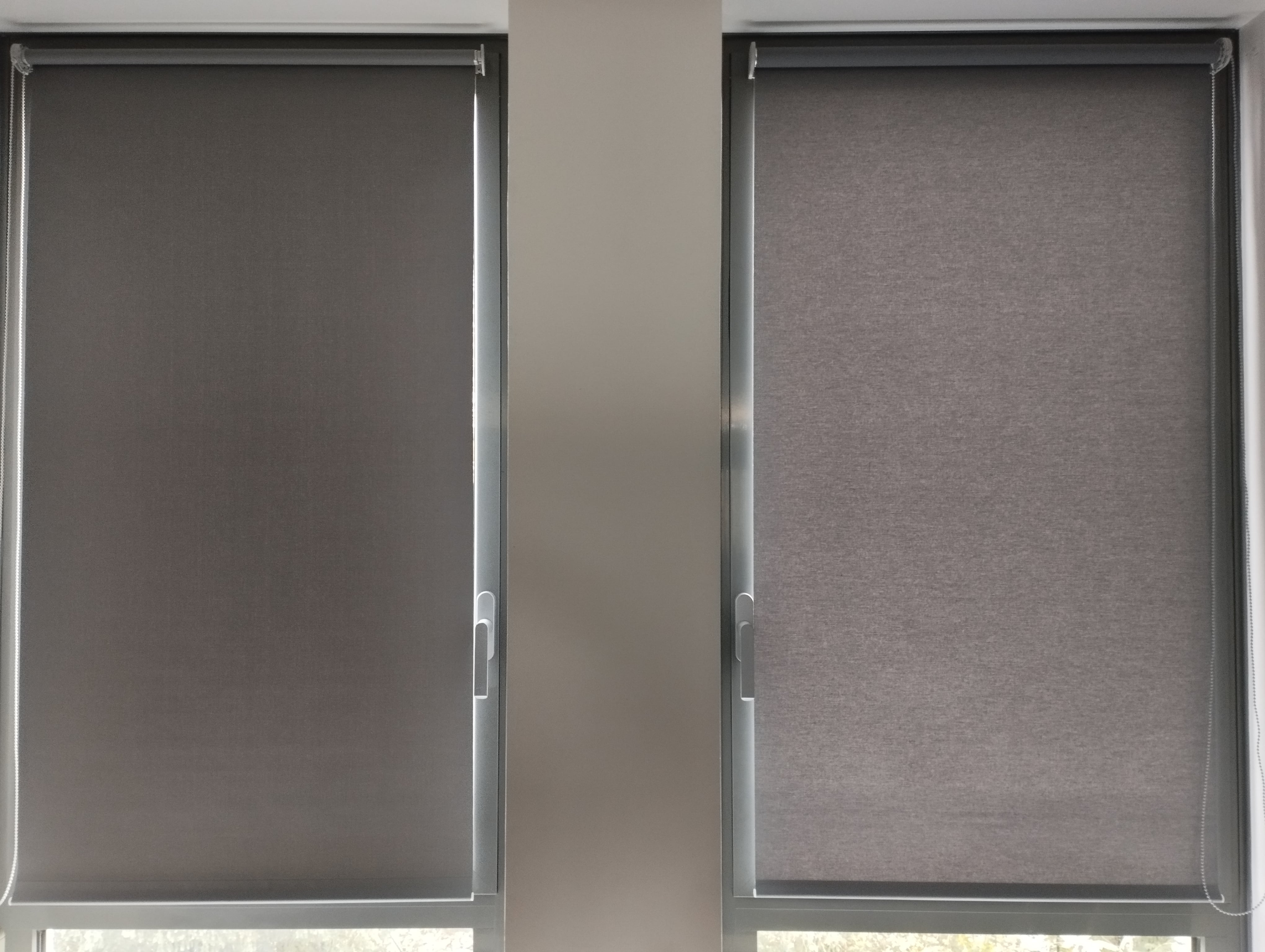Stores enrouleurs occultants gris installés sur fenêtres, solution de protection solaire intérieure moderne en Alsace