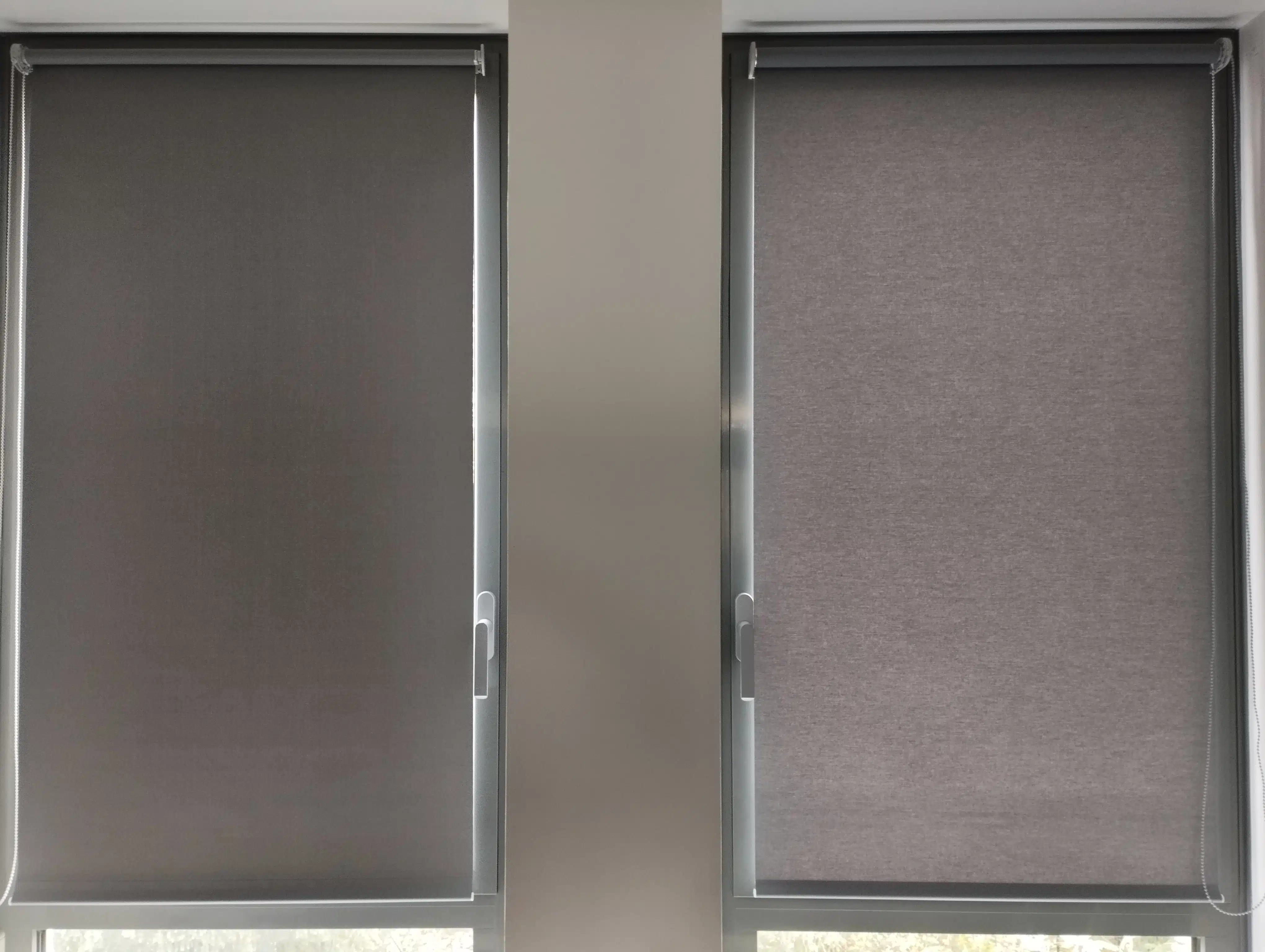Stores enrouleurs occultants gris installés sur fenêtres, solution de protection solaire intérieure moderne en Alsace